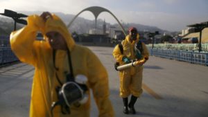 Municipal workers walk after spraying insecticide at Sambodrome in Rio de Janeiro